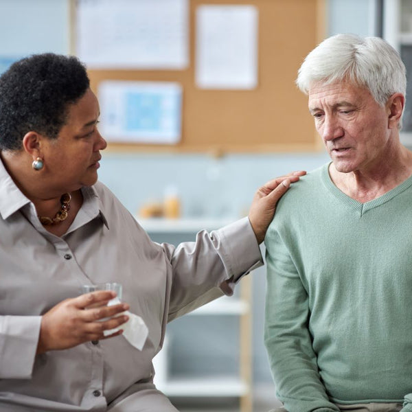 Elderly man being consoled after elder abuse