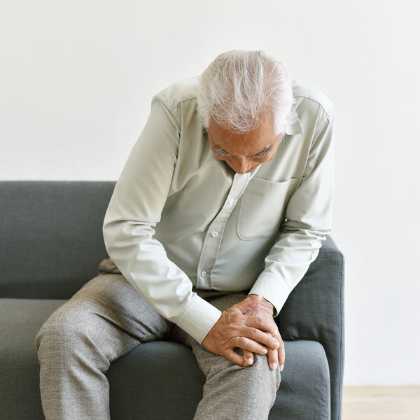 Elderly man sitting with pain in the knee