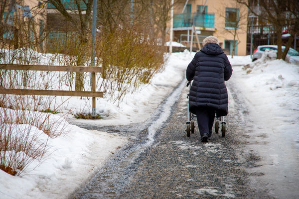 Elderly woman walking on icy pavements