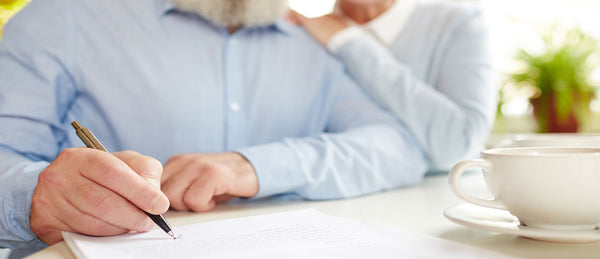 Elderly man signing will for estate planning