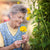 Elderly woman with a colourful flower in her garden