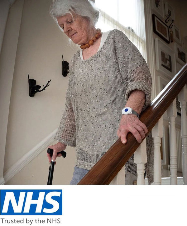 Older lady walking down stairs wearing fall alarm