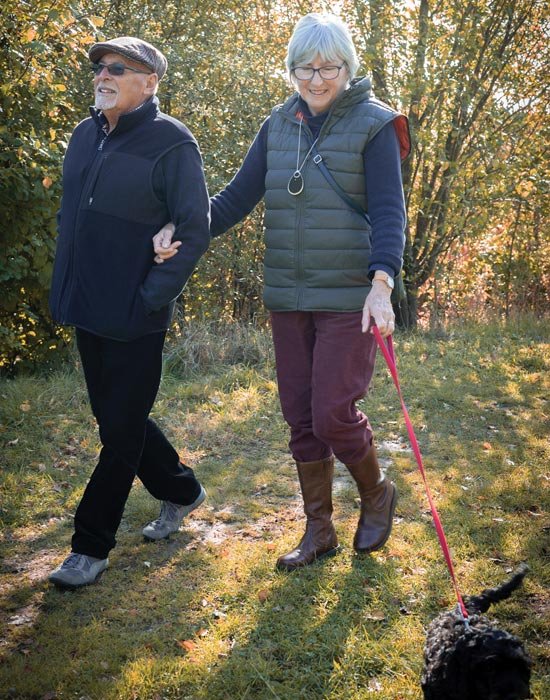 Elderly couple walking dog