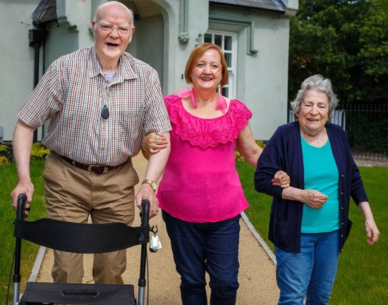 Man wearing panic alarm with GPS and fall detection with wife and daughter