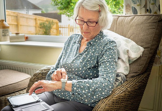 Elderly lady pressing digital personal alarm button