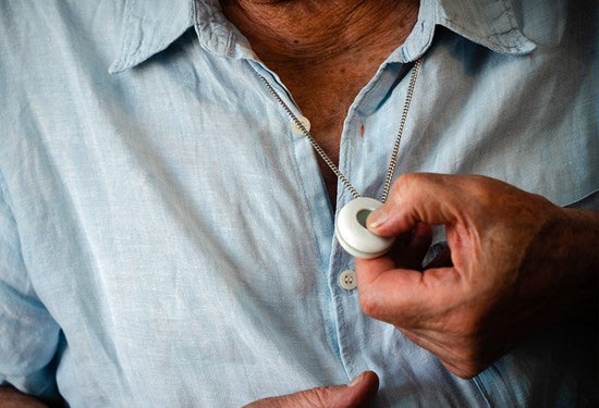 Older man pressing digital personal alarm button