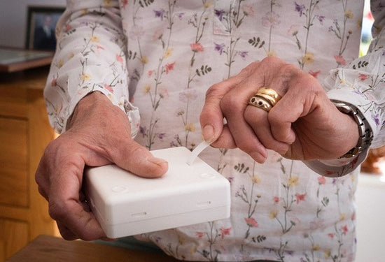 Elderly person setting up Taking Care Sense