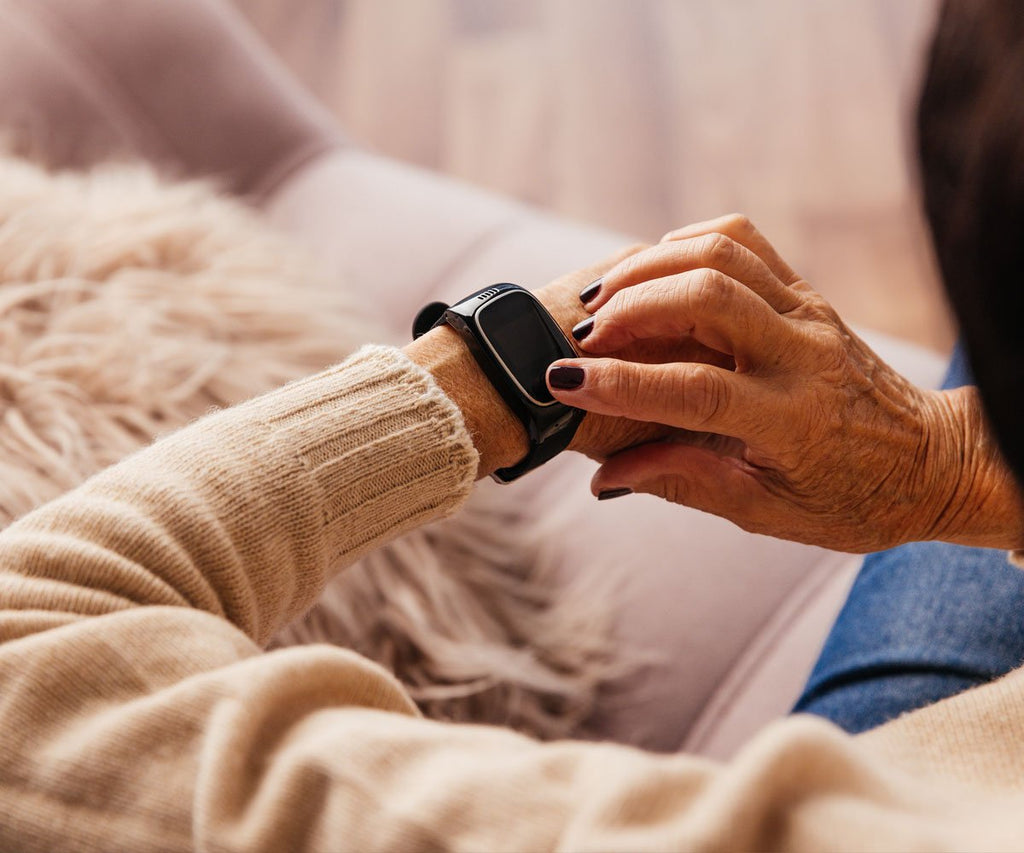Person wearing a beige sweater using a dementia tracker with a blurred background