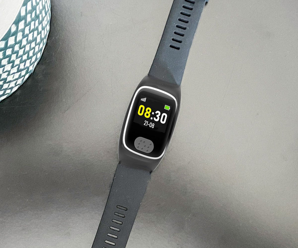 Dementia tracker watch with a gray strap on a light gray surface
