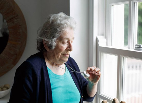 Elderly lady pressing single button personal alarm