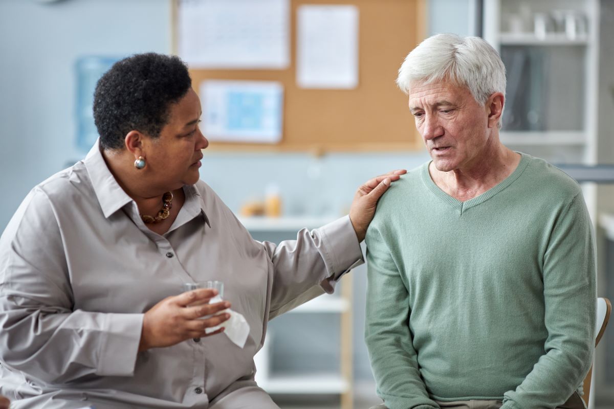 Elderly man being consoled after elder abuse