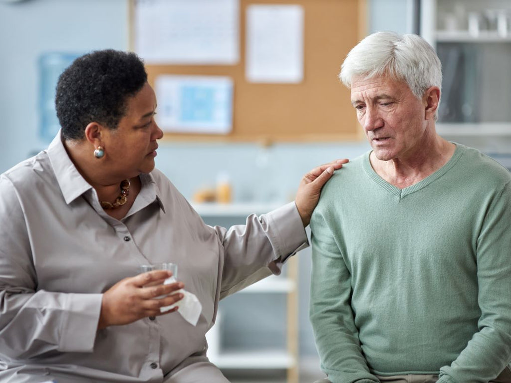 Elderly man being consoled after elder abuse