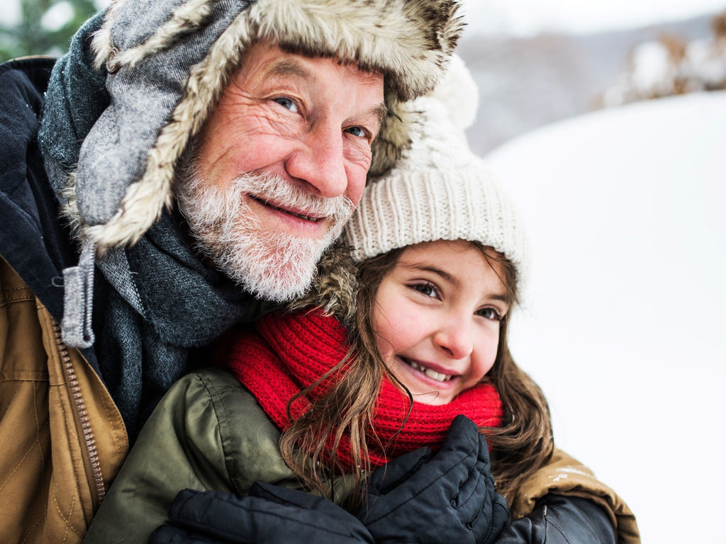 Grandfather enjoying in snow with little girl