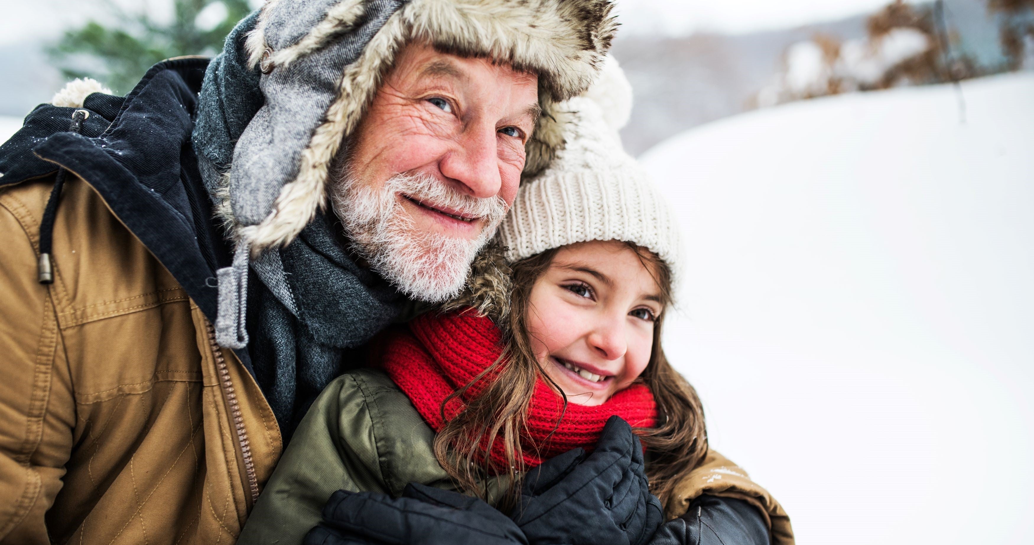 Grandfather enjoying in snow with little girl