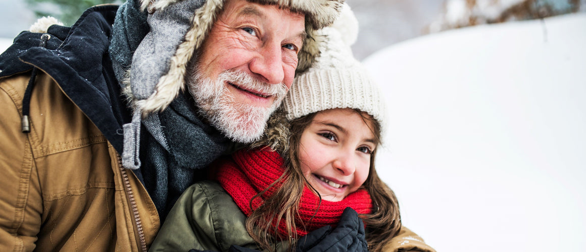Grandfather enjoying in snow with little girl