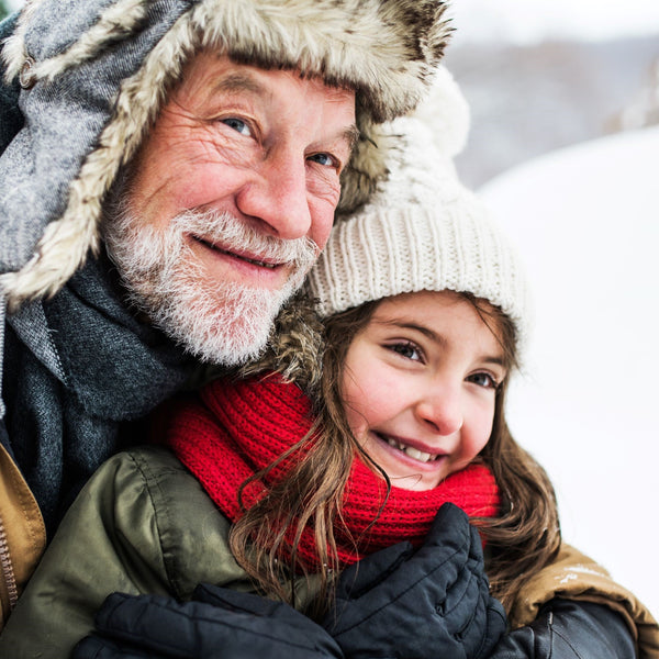 Grandfather enjoying in snow with little girl