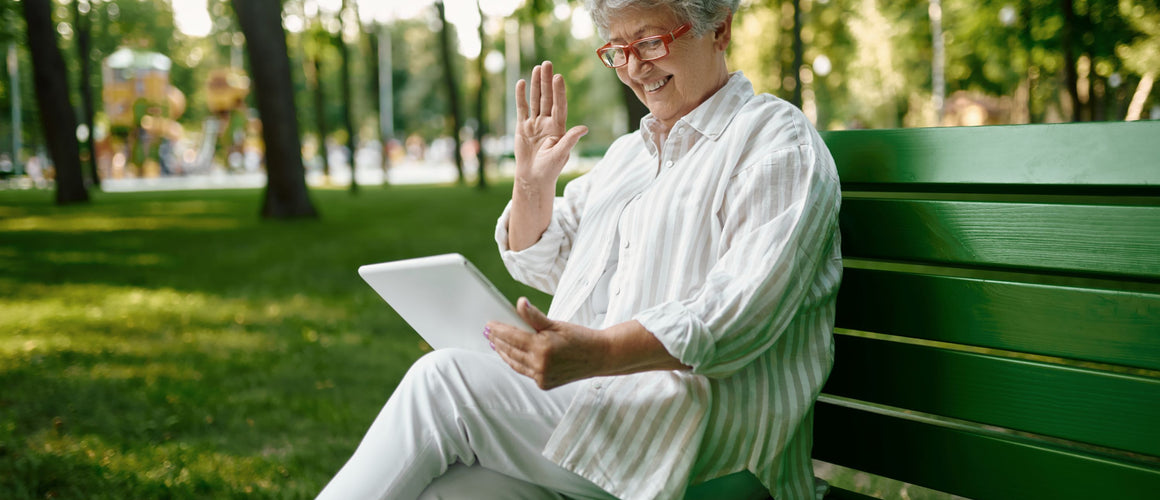 Elderly woman using her tablet outside