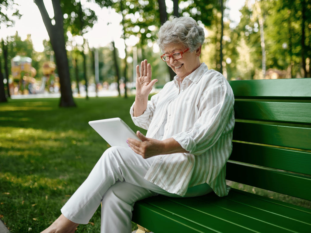 Elderly woman using her tablet outside