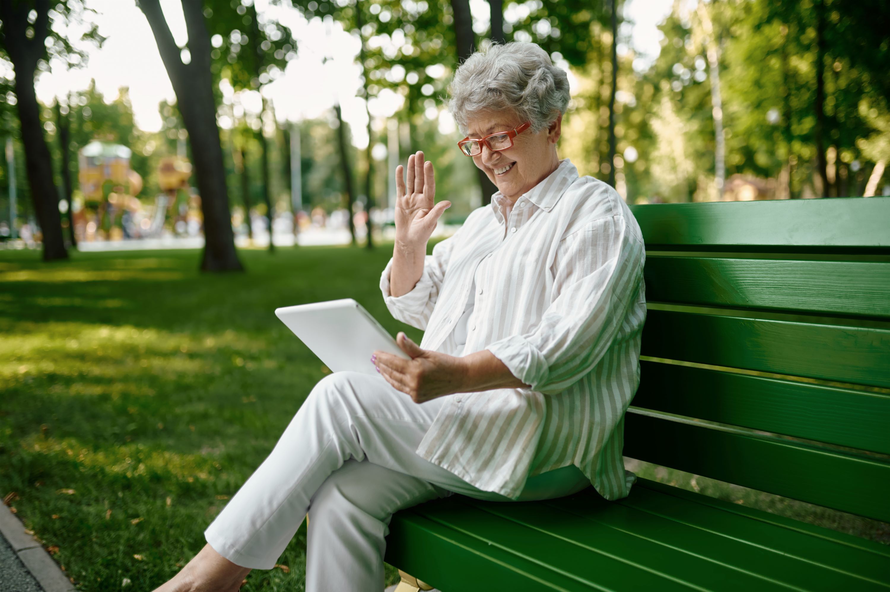 Elderly woman using her tablet outside