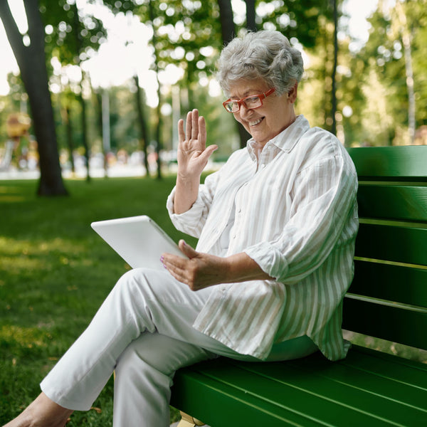 Elderly woman using her tablet outside