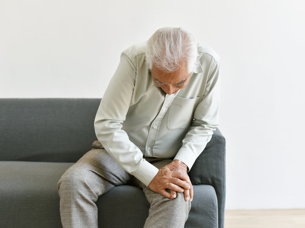 Elderly man sitting with pain in the knee
