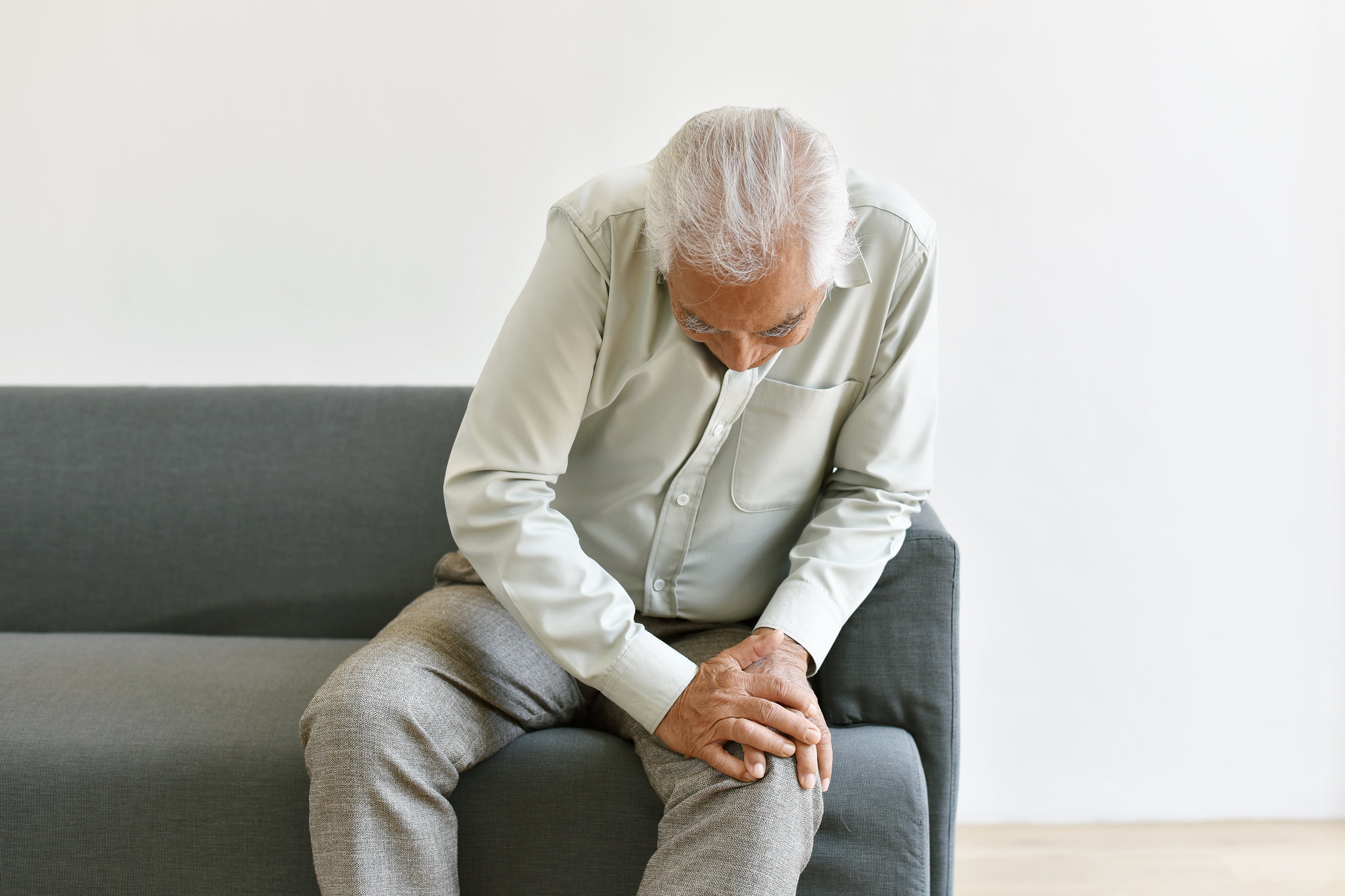 Elderly man sitting with pain in the knee
