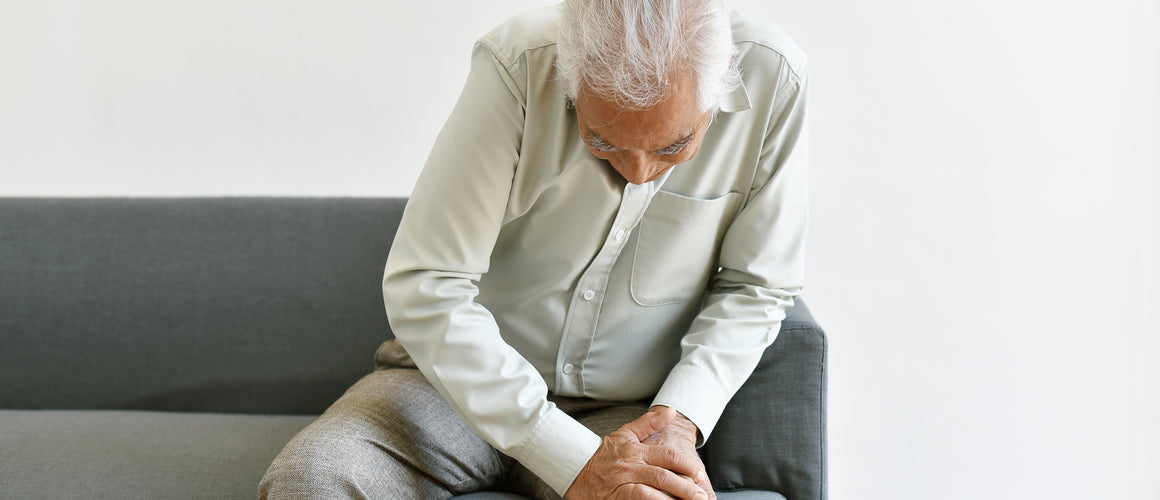 Elderly man sitting with pain in the knee