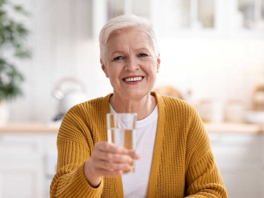 Elderly woman holding a glass of water