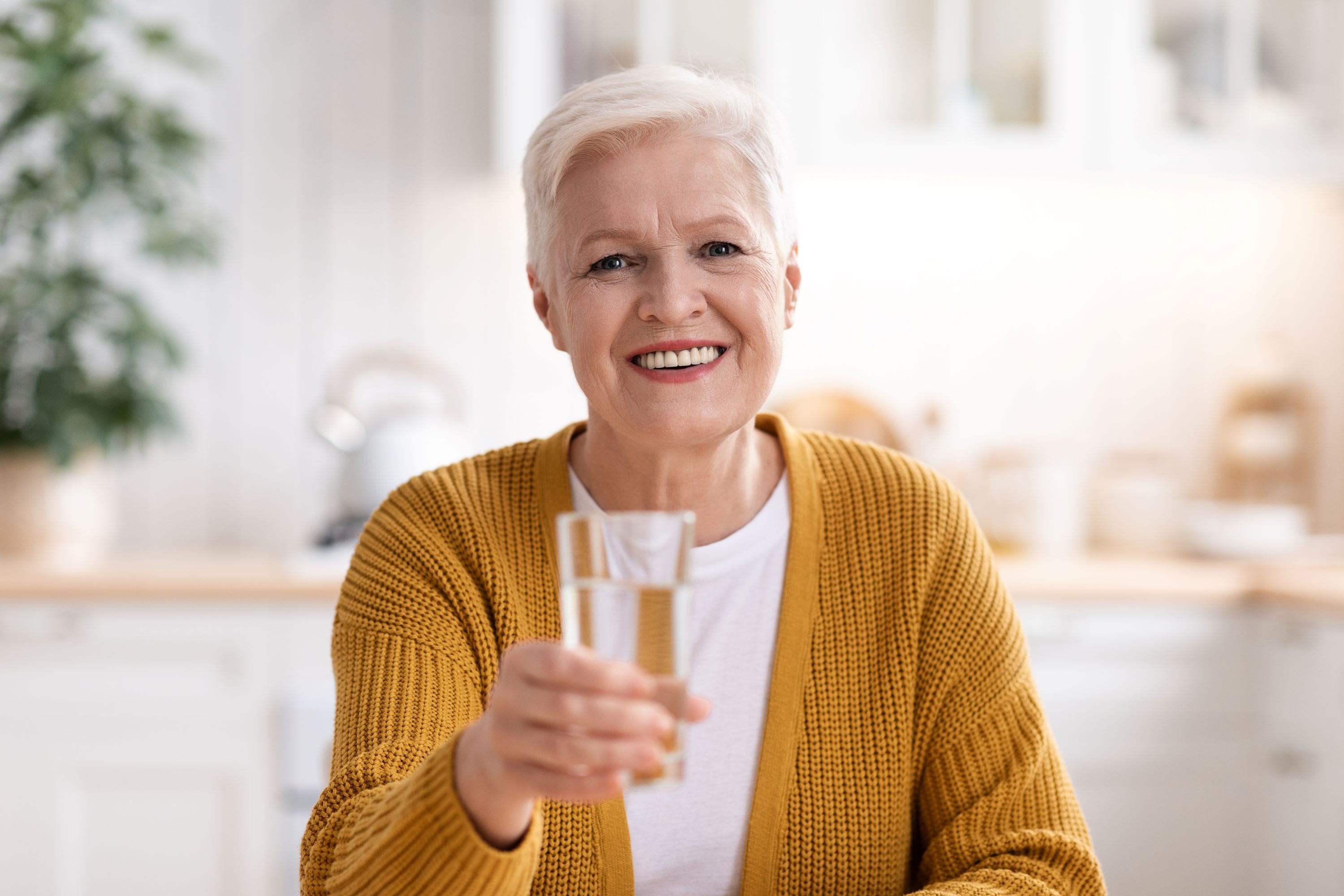 Elderly woman holding a glass of water