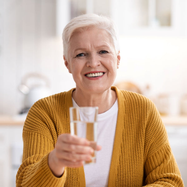 Elderly woman holding a glass of water