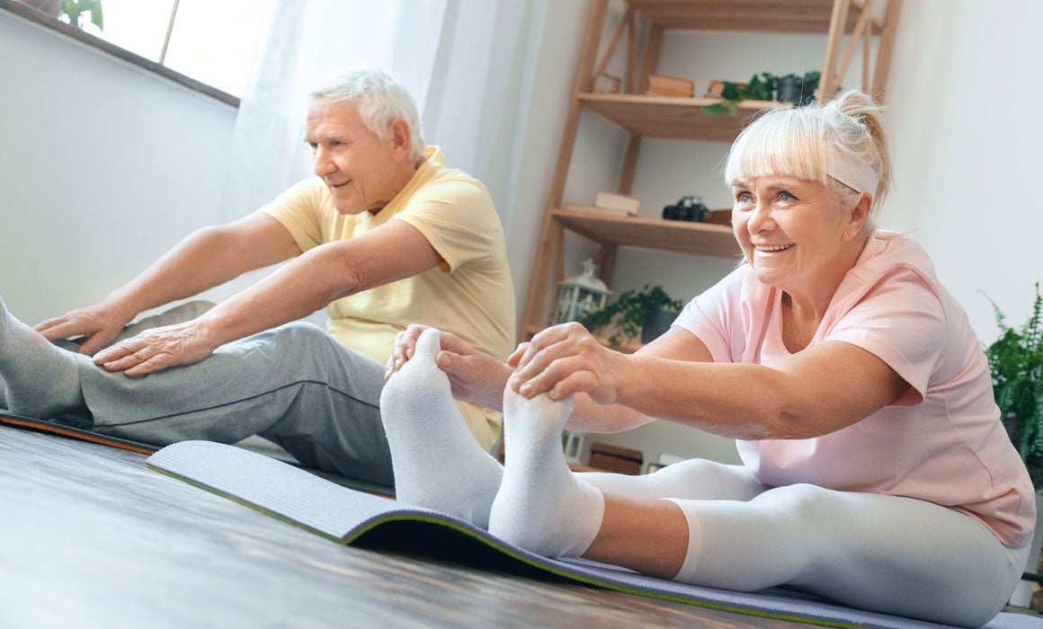 Older man and woman doing yoga exercise at home
