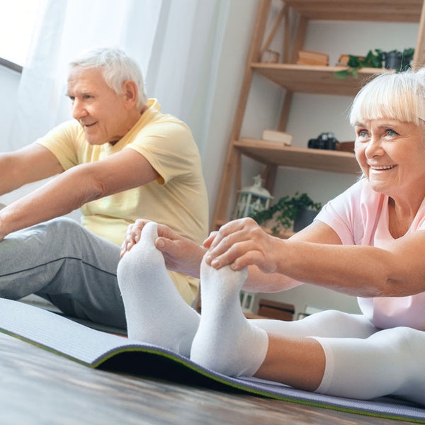 Older man and woman doing yoga exercise at home