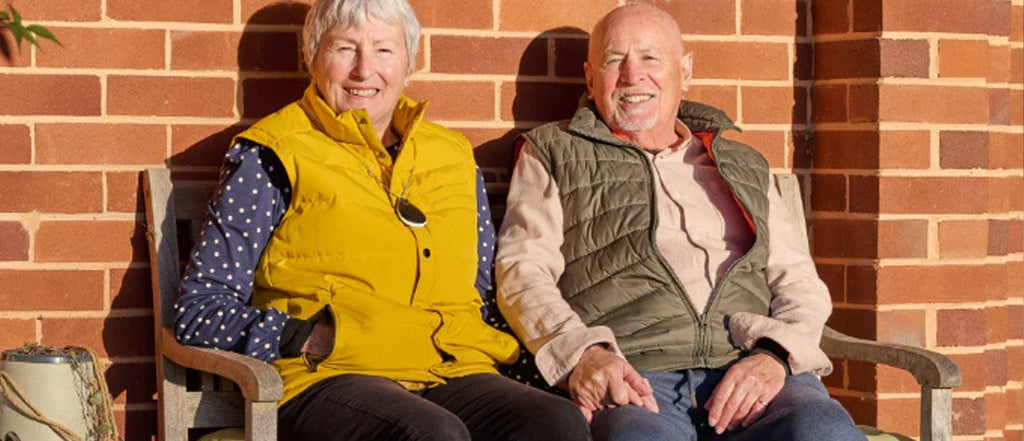 Two older adults sat on a bench