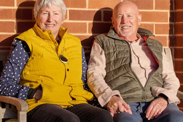 Two older adults sat on a bench