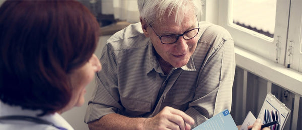 Elderly man looking at stroke results with doctor