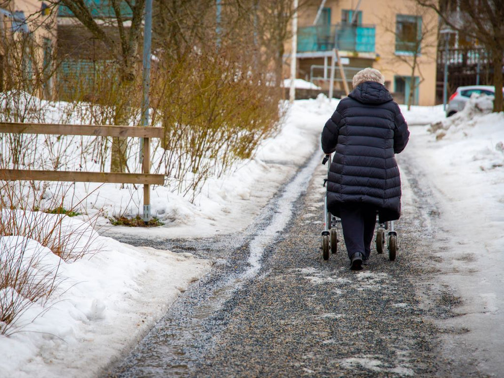 Elderly woman walking on icy pavements