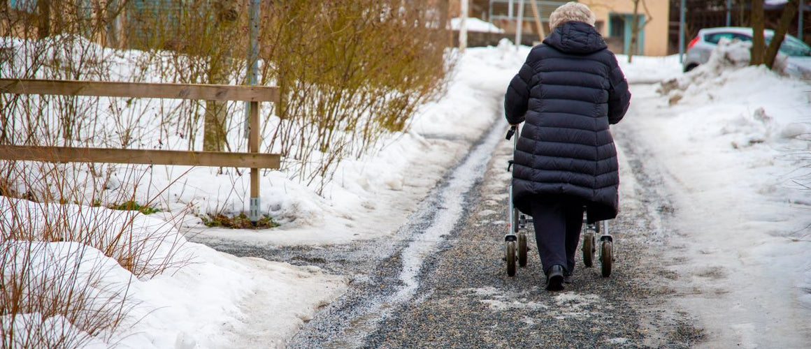Elderly woman walking on icy pavements
