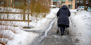 Elderly woman walking on icy pavements