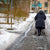 Elderly woman walking on icy pavements