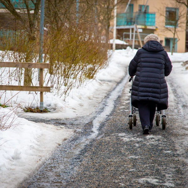 Elderly woman walking on icy pavements