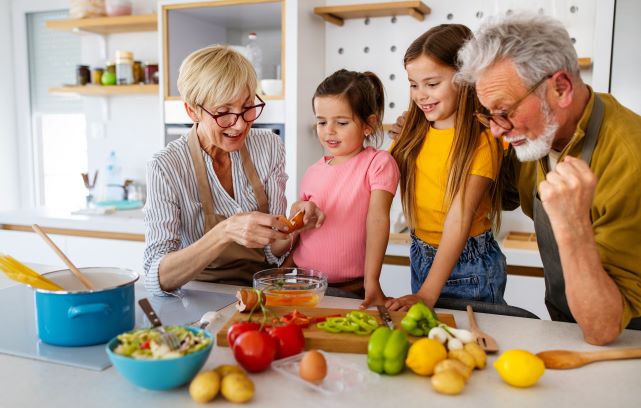Grandparents cooking healthy food with grandchildren