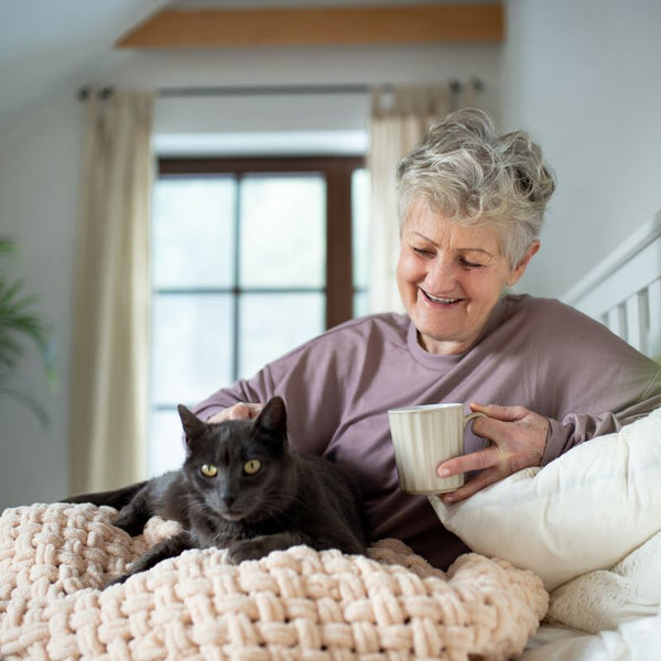 Elderly woman with her cat at home