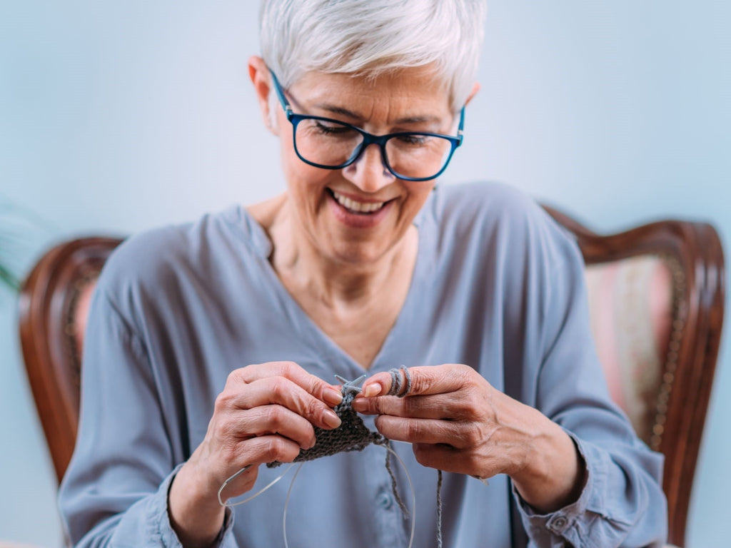 Elderly woman knitting happily