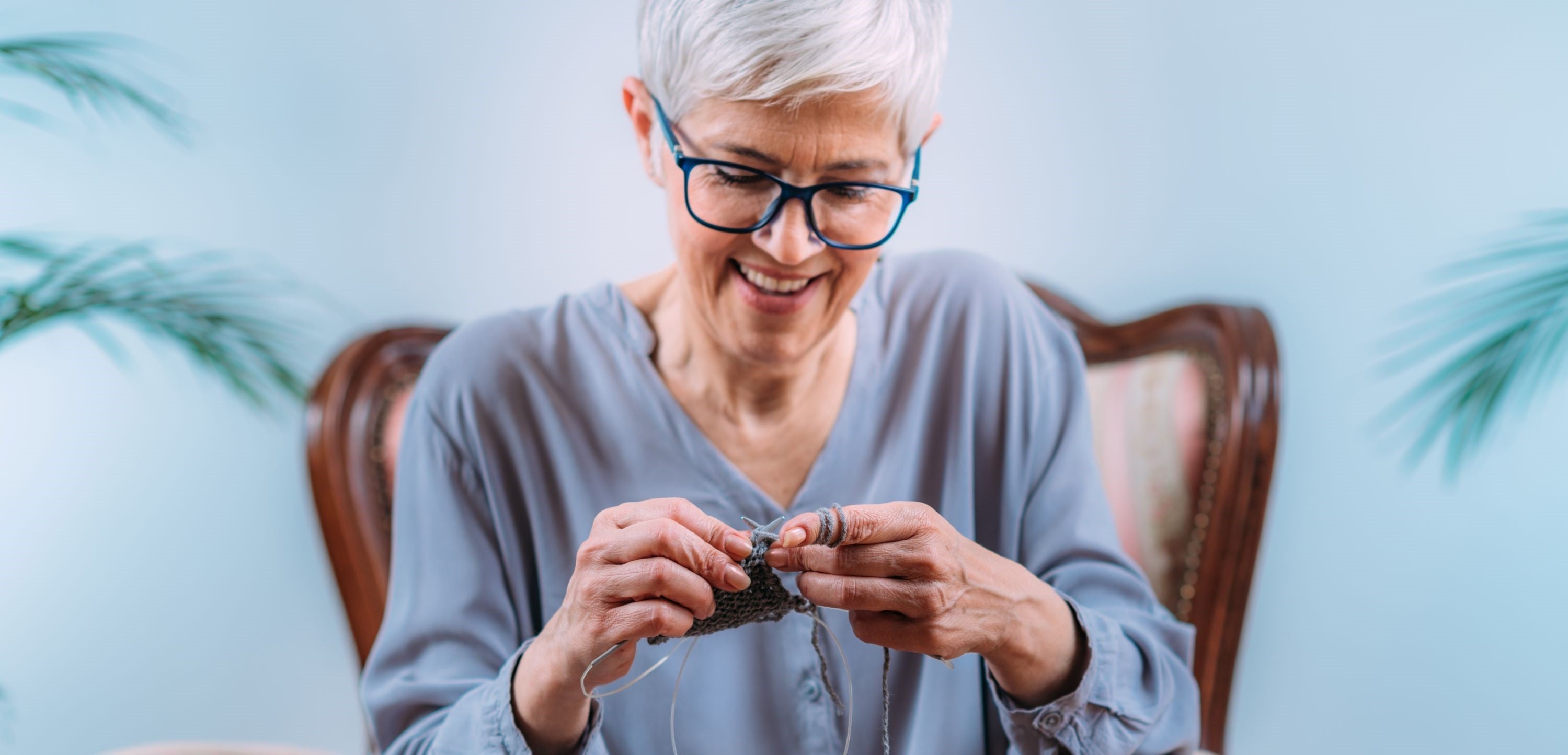 Elderly woman knitting happily