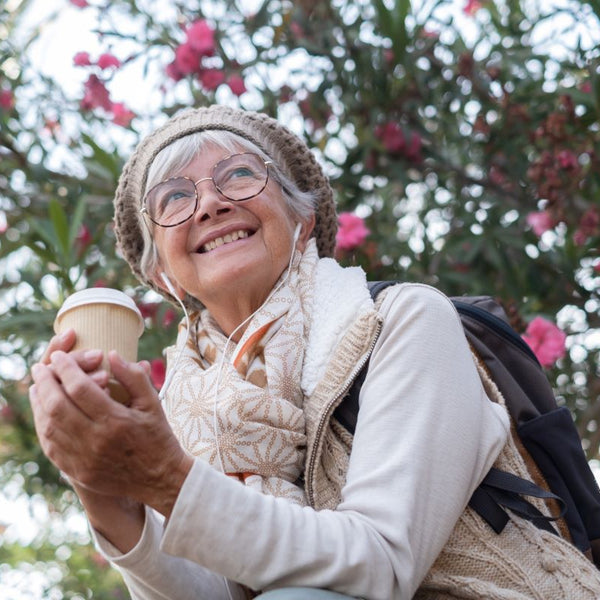 Happy elderly woman having coffee outdoors