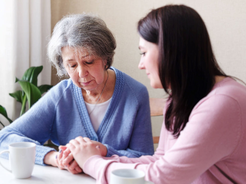 Woman consoling sad old woman