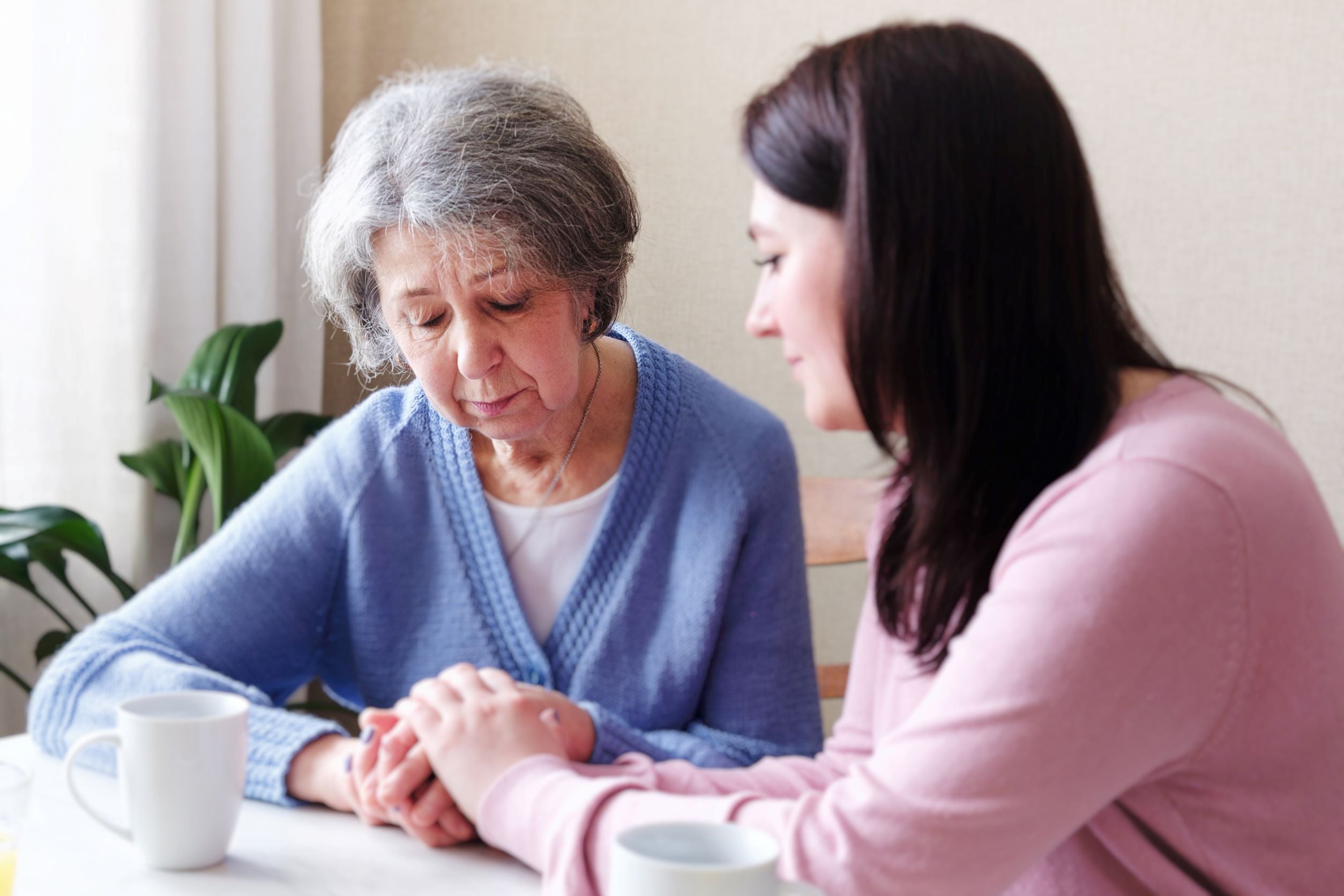 Woman consoling sad old woman