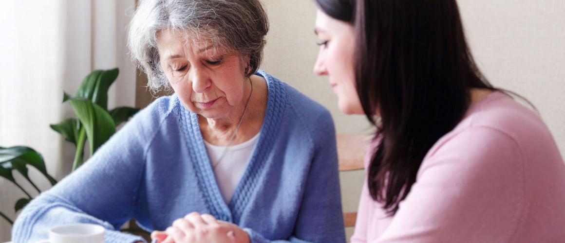 Woman consoling sad old woman