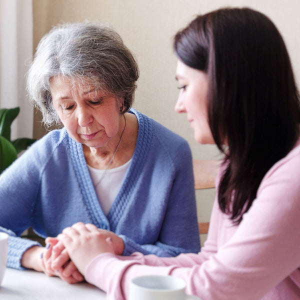 Woman consoling sad old woman