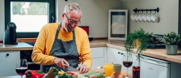 Elderly man preparing food in kitchen alone